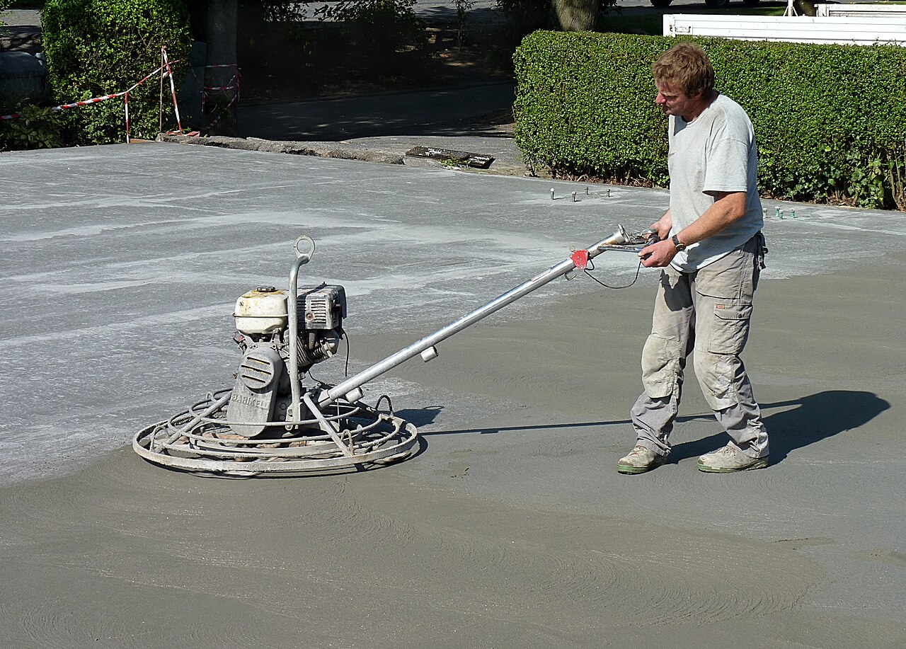 Worker polishing a concrete slab with a polishing machine, picture taken in Belgium.